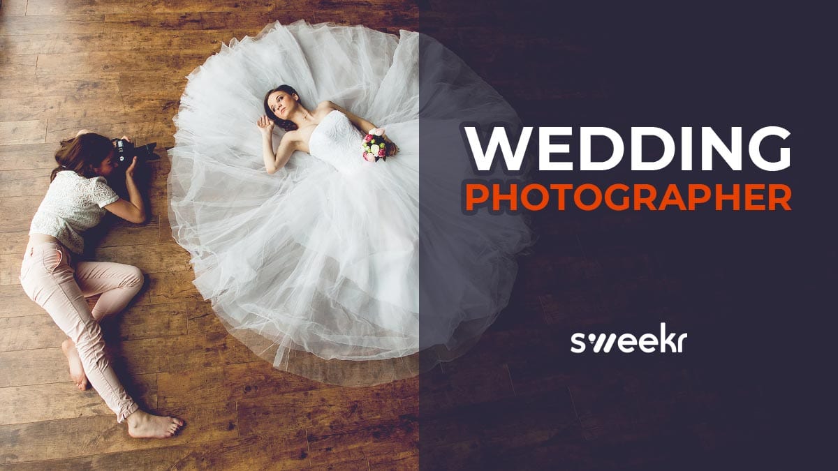 A photographer and a bride both lying on the floor to take an artistic picture